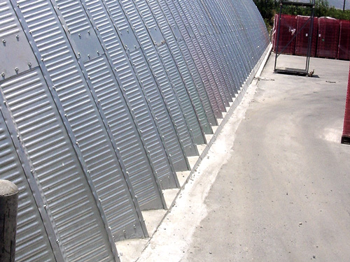 Samonośne hale łukowe - prefabrykowana stalowa hala łukowa - montaż z uszczelnieniem łuków betonem.